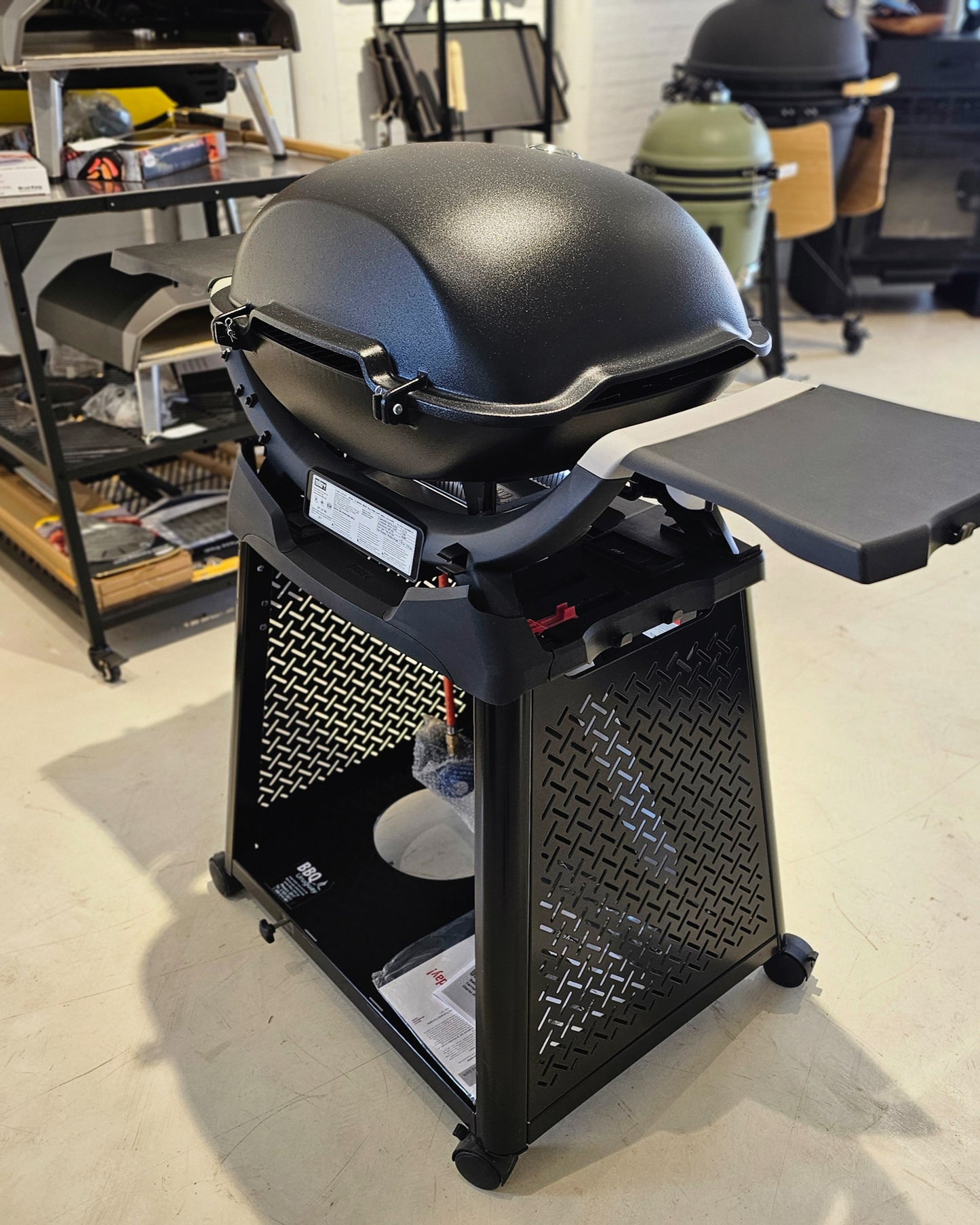 Barbacoa a gas Weber Q 3200 con stand y mesas plegables.