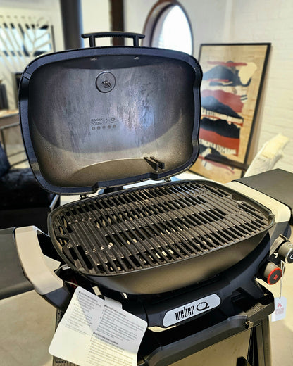 Barbacoa a gas Weber Q 3200 con stand y mesas plegables.